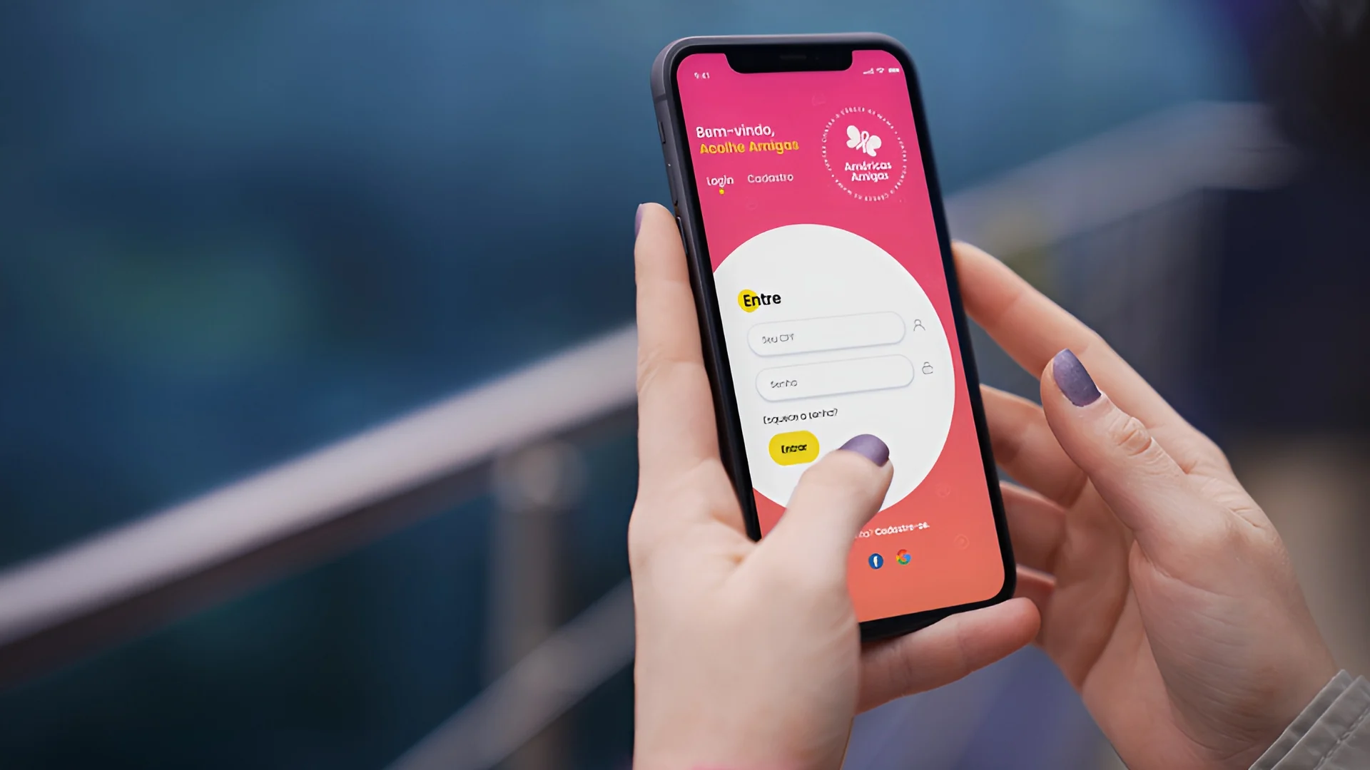 Mãos segurando celular com o app Acolhe Amigas da Américas Amigas